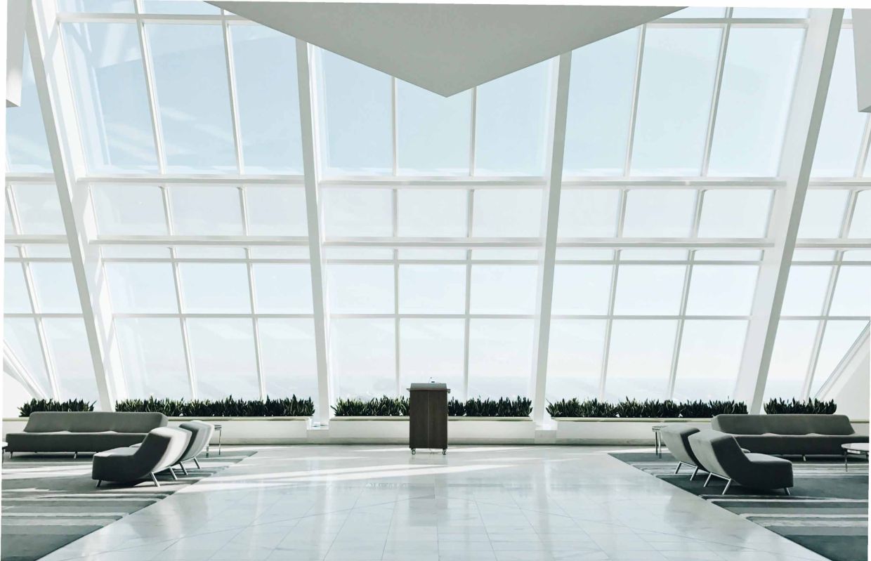 Hall d’un centre administratif moderne avec baies vitrées et mobilier épuré, représentant un service de nettoyage et d’entretien professionnel à Genève par Alfredo Services.