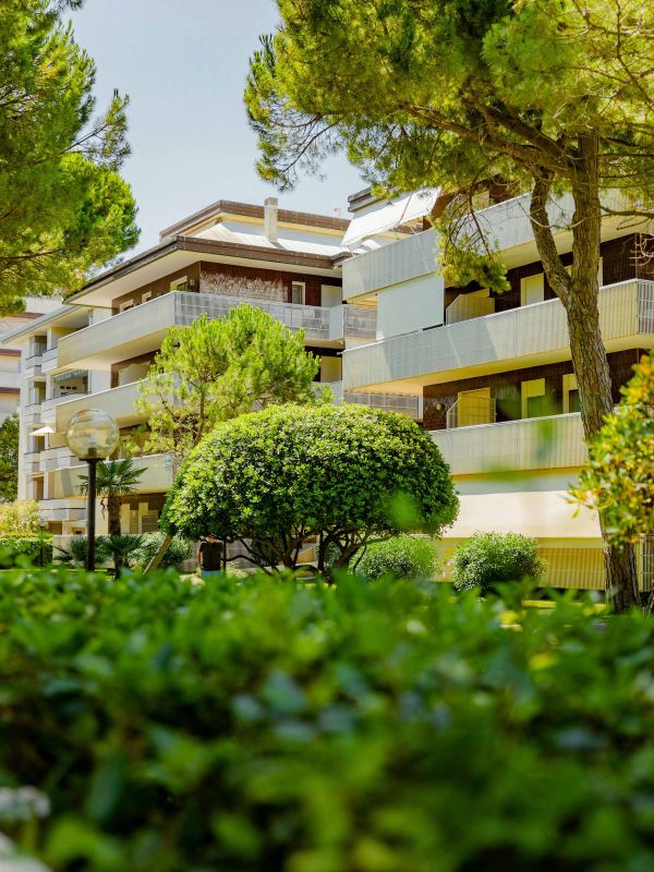 Immeuble résidentiel contemporain avec balcons vitrés et plantes, représentant un service de gestion et d’entretien d’immeubles à Genève par Alfredo Services.